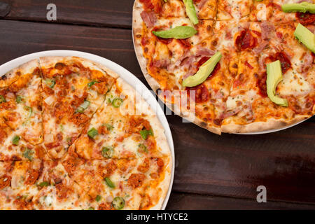 Pizza on dark wooden table top with fresh ingredients Stock Photo