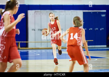 Girls athlete in sport uniform playing basketball indoors Stock Photo