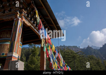 Bhutan, Paro. Colorful prayer flages in front of small outbuilding of the Tiger's Nest, sacred Himalayan Buddhist temple complex. Stock Photo