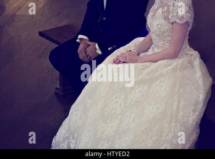 Bride and groom sitting on a bench Stock Photo