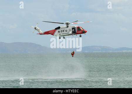 British HM Coastguard helicopter Sikorsky S-92 operated by Bristow Helicopters conducting a rescue exercise off the coast of Moelfre Anglesey Wales Stock Photo