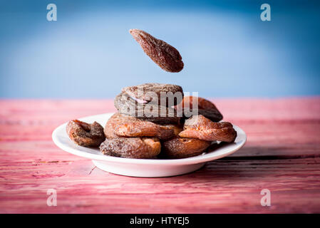 Group of dried apricots ion the white plate on the wooden table Stock Photo