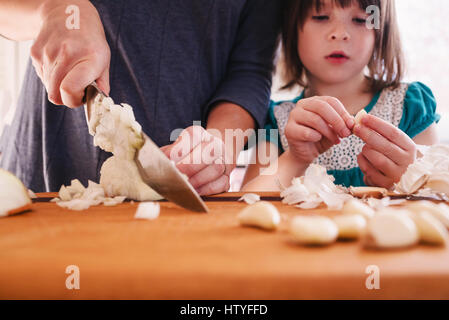 Girl helping her mother cook food Stock Photo