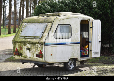 Dirty old-fashioned Polish-made caravan of polyester on a camping site in The Netherlands Stock Photo