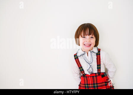 Portrait of as smiling girl leaning against a wall Stock Photo
