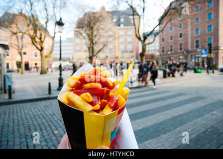 Holding trypical belgian fries in hand in the streets of Brussels Stock Photo