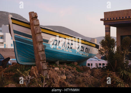 A boat a the entrance to the beach of Aglou in Morocco wiht the words Aglou Plage written on it. Stock Photo