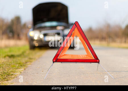 breakdown triangle stands near a broken car Stock Photo