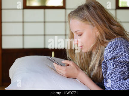Caucasian woman wearing yukata in traditional Japanese house futon Stock Photo