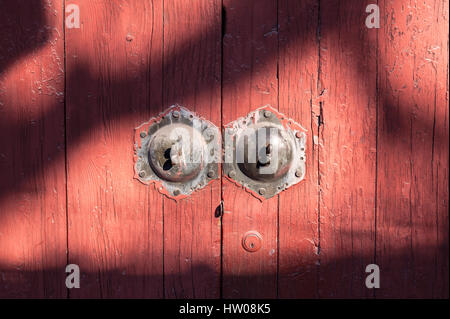Old red wooden door with patterned shadows, Beijing, China Stock Photo