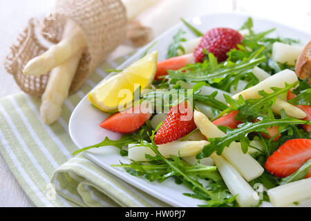 Colorful spring salad with fresh white asparagus, rocket salad and strawberries Stock Photo