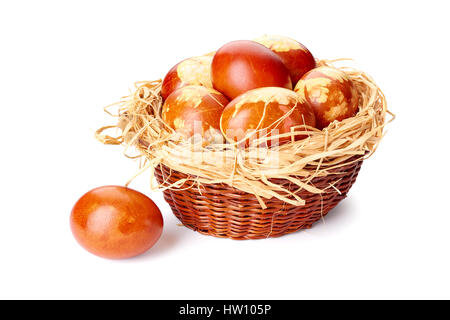 Colorful decorated easter eggs in small wicker baket on white Stock Photo