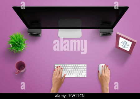 Top view work desk scene with computer display, keyboard, and mouse. Woman typing and use mouse. Free space for text. Pink desk. Stock Photo