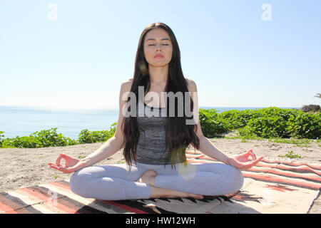 Beautiful woman meditating outdoors with eyes closed. Stock Photo