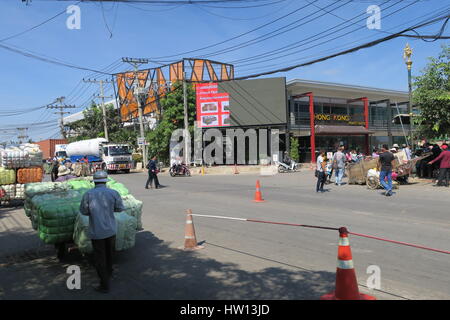 Local people are crossing Cambodia Thailand border with wooden wagons, filled with stuff in a plastic bags. Stock Photo