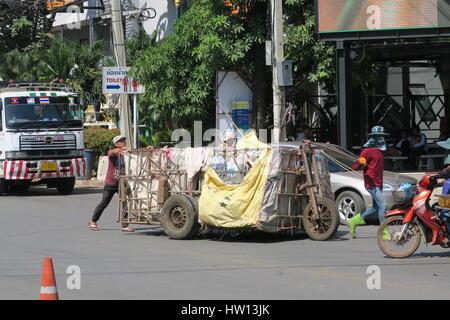 Local people are crossing Cambodia Thailand border with wooden wagons, filled with stuff in a plastic bags. Stock Photo