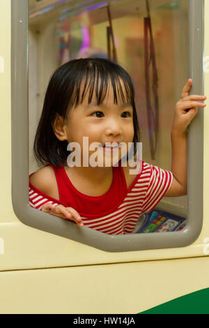 Little Asain Chinese Bus Driver at indoor playground Stock Photo