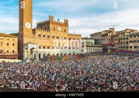 SIENA, ITALY - JUNE 29, 2016: Crowd of people in Piazza del Campo square in Siena, Italy, watching traditional Palio di Siena horse race. Stock Photo