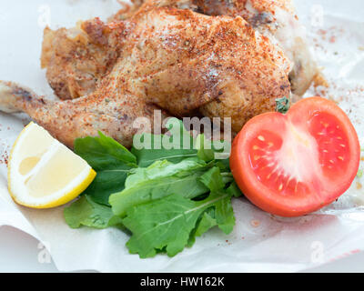 Whole roast grilled chicken with veggies on a paper Stock Photo