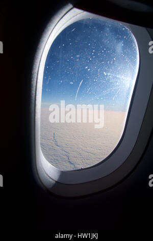 OSLO, NORWAY - JAN 21st, 2017: Closeup of the airplane window with the clouds sky background. Stock Photo