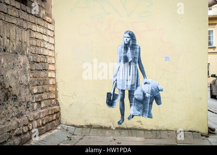 Woman holding bear and spade. Painting on wall. Stock Photo