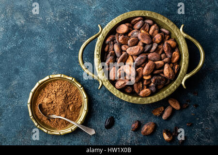 Cocoa beans and powder on dark background, top view, copy space, flat lay Stock Photo