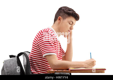 Profile shot of a teenage student sitting in a chair and taking notes isolated on white background Stock Photo