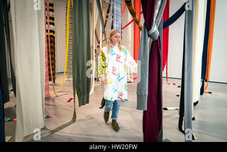 Annabelle Syms, wearing clothes designed by fashion designer Jonathan Anderson, looks at 28 Jumpers, also by the designer, which features in the Disobedient Bodies: JW Anderson curates The Hepworth Wakefield exhibition at The Hepworth Wakefield art gallery in Yorkshire. Stock Photo