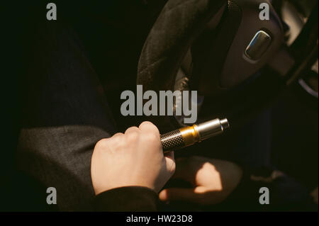 young vaper man with beard vaping mechanical mod. Guy smokes an electronic cigarette by blowing a smoke vapor. Holds in hand Sitting at the wheel of a Stock Photo