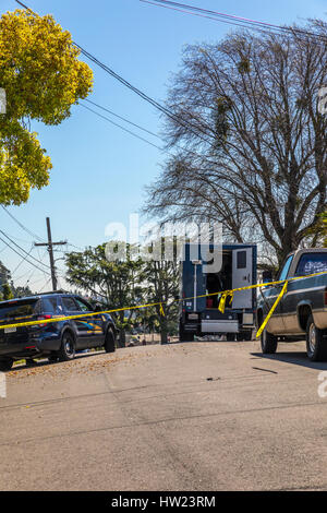 A crime scene with forensic experts where a drug related murder occurred after a noisy fight broke out in a quiet San Leandro California neighborhood Stock Photo