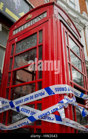 Police crime scene tape wrapped around a red phone box in Soho, on 8th March 2017, London borough of Westminster, England. Stock Photo