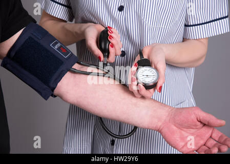 Nurse using a blood pressure monitor on a patient Stock Photo