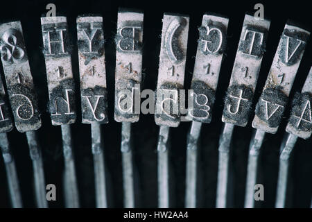 Close up shot of metal pieces with letters in typing machine mechanism. Stock Photo