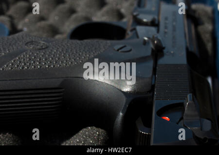 A closeup of a black gun in a case lined with foam. Stock Photo