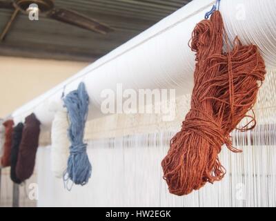 Skiens of natural dyed yarn hanging on a loom. Stock Photo