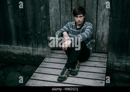 Caucasian man sitting on wooden dock Stock Photo