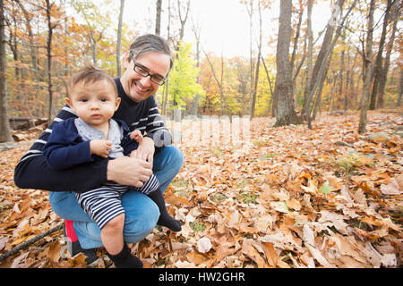 Father holding baby son outdoors in autumn Stock Photo