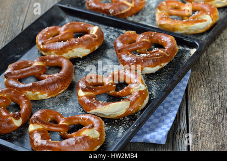Oven fresh handmade crispy Bavarian pretzels on a baking sheet Stock Photo