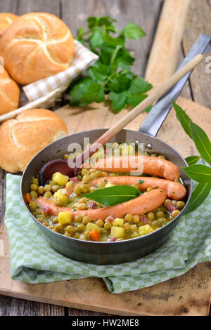 Hearty pea stew with potatoes, bacon and Vienna sausages Stock Photo