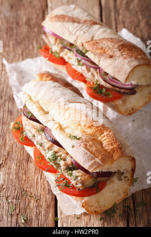 Sandwiches with fried mackerel and vegetables close-up on the table. vertical Stock Photo