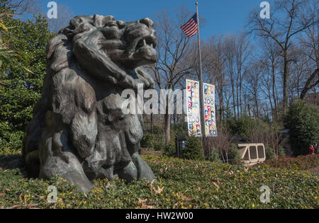 Entrance to the Washington National Zoo in late winter, part of the Smithsonian Institution. One of two bronze Perry Lions at Connecticut Ave. basks. Stock Photo