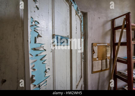 Door of headmaster office in secondary school in Mashevo abandoned village of Chernobyl Nuclear Power Plant Zone of Alienation in Ukraine Stock Photo