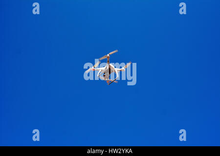 Aircraft type Dron photographed from the ground in flight and shooting events below it Stock Photo