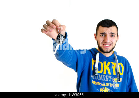 Scared teenager man hold key cars before driving isolated on white background Stock Photo