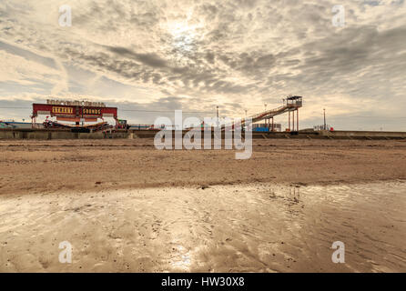 HUNSTANTON, ENGLAND - MARCH 10: Hunstanton fairground from the beach as sunset approaches. HDR image. In Hunstanton, Norfolk, England. On 10th March 2 Stock Photo