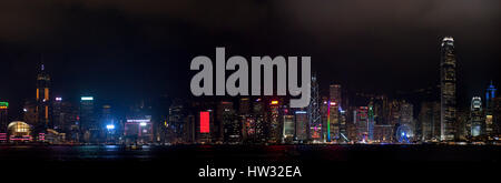 A 3 picture stitch panoramic colourful cityscape view of the buildings along Hong Kong Island from the Kowloon Public Pier at night. Stock Photo