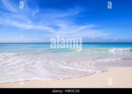 Tropical beach background, white sand, azure shore water under cloudy blue sky. Caribbean Sea coast, Dominican republic, Saona island Stock Photo