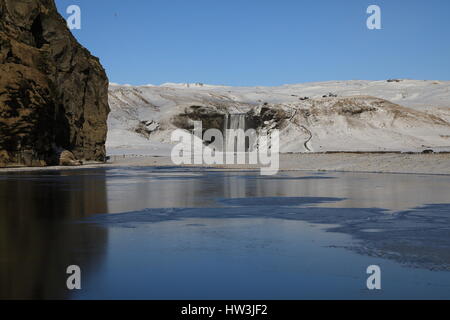 Iceland, Skogar, Skogafoss, Skogafoss waterfall surrounded by snow and ice in winter Stock Photo