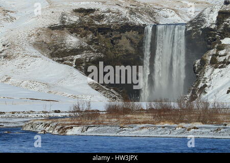 Iceland, Skogar, Skogafoss, Skogafoss waterfall surrounded by snow and ice in winter Stock Photo