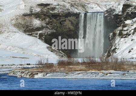 Iceland, Skogar, Skogafoss, Skogafoss waterfall surrounded by snow and ice in winter Stock Photo